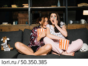portrait two frightened female friends watching television. Стоковое фото, агентство Ingram Publishing / Фотобанк Лори