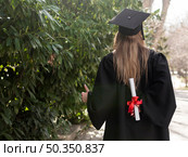 back view woman holding her diploma. Стоковое фото, агентство Ingram Publishing / Фотобанк Лори