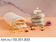 rolled up towel lighted candle spa stones rose himalayan salts peach colored backdrop. Стоковое фото, агентство Ingram Publishing / Фотобанк Лори