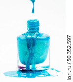 close up blue glitter nail polish dropping its flask against white background. Стоковое фото, агентство Ingram Publishing / Фотобанк Лори
