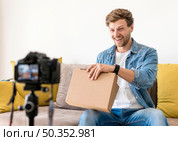handsome male recoding unboxing video home. Стоковое фото, агентство Ingram Publishing / Фотобанк Лори
