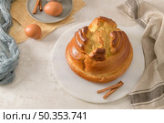 Fogaca on kitchen countertop with eggs and cinammon sticks. Traditional cake from Santa Maria da Feira, Portugal. Стоковое фото, агентство Ingram Publishing / Фотобанк Лори