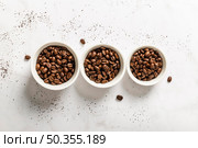 top view three cups with roasted coffee beans. Стоковое фото, агентство Ingram Publishing / Фотобанк Лори