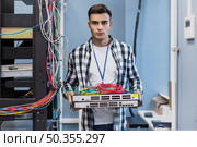 young man holding ethernet switches wires. Стоковое фото, агентство Ingram Publishing / Фотобанк Лори
