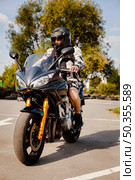 biker motorbike waiting cross road. Редакционное фото, агентство Ingram Publishing / Фотобанк Лори