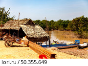 Thatched Home and Waterside Life Along Tonle Sap Lake in Cambodia (2014 год). Редакционное фото, фотограф Aleksandr Golubev / Фотобанк Лори