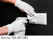 hands with gloves disinfecting light switches. Стоковое фото, агентство Ingram Publishing / Фотобанк Лори