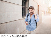 happy man walking pavement listening music. Стоковое фото, агентство Ingram Publishing / Фотобанк Лори