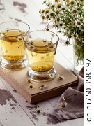 chamomile tea cups wooden board. Стоковое фото, агентство Ingram Publishing / Фотобанк Лори