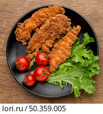 top view fried chicken with tomatoes salad plate. Стоковое фото, агентство Ingram Publishing / Фотобанк Лори