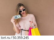 amazed woman standing with shopping bags money. Стоковое фото, агентство Ingram Publishing / Фотобанк Лори