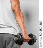 back view very fit man holding weight. Стоковое фото, агентство Ingram Publishing / Фотобанк Лори