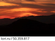 dark yellow clouded sky with black mountains. Стоковое фото, агентство Ingram Publishing / Фотобанк Лори