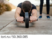 front view man exercising with ab wheel outdoors. Стоковое фото, агентство Ingram Publishing / Фотобанк Лори