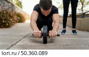 front view man exercising with ab wheel outside. Стоковое фото, агентство Ingram Publishing / Фотобанк Лори
