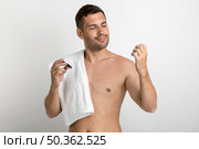 handsome man with towel looking his nails while holding nail clipper. Стоковое фото, агентство Ingram Publishing / Фотобанк Лори