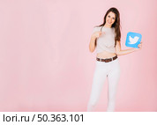 portrait smiling young woman pointing twitter icon. Стоковое фото, агентство Ingram Publishing / Фотобанк Лори