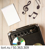spiral notepad musical note amplifier with compact disc wooden desk. Стоковое фото, агентство Ingram Publishing / Фотобанк Лори