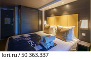 Tokyo, Japan - Oct 2 2024, panoramic view of interior of living cabin with four beds, illuminated by bedside lamps and overhead light, without people, on the MSC Bellissima cruise ship, Tokyo, Japan. Редакционное фото, фотограф Сергей Богомяко / Фотобанк Лори