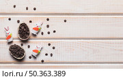 three white bunnies with broken easter egg filled with choco chips wooden desk. Стоковое фото, агентство Ingram Publishing / Фотобанк Лори