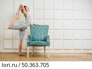 woman stretching armchair. Стоковое фото, агентство Ingram Publishing / Фотобанк Лори