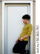 young curly hispanic man leaning door casing. Стоковое фото, агентство Ingram Publishing / Фотобанк Лори