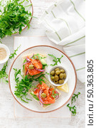 Open sandwiches with salted salmon, avocado, olives and arugula. Breakfast. Top view. Стоковое фото, агентство Ingram Publishing / Фотобанк Лори
