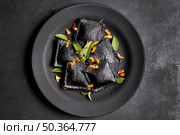 minimalist flat lay black ravioli plate. Стоковое фото, агентство Ingram Publishing / Фотобанк Лори