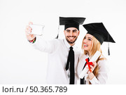 couple graduating taking selfie. Стоковое фото, агентство Ingram Publishing / Фотобанк Лори