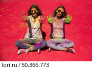 portrait two young women showing their palms painted with holi color. Стоковое фото, агентство Ingram Publishing / Фотобанк Лори