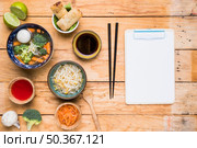 thai soup spring rolls sauces sprout beans with chopstick white paper clipboard wooden table. Стоковое фото, агентство Ingram Publishing / Фотобанк Лори