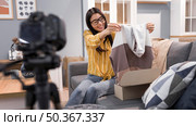 vlogger home unboxing clothes. Стоковое фото, агентство Ingram Publishing / Фотобанк Лори