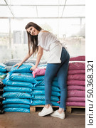 portrait happy woman front stacked plastic sacks. Стоковое фото, агентство Ingram Publishing / Фотобанк Лори