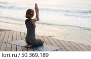 full shot woman doing yoga pose mat outside. Стоковое фото, агентство Ingram Publishing / Фотобанк Лори