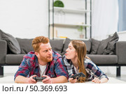 young woman teasing her boyfriend while playing video game living room. Стоковое фото, агентство Ingram Publishing / Фотобанк Лори