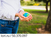 midsection girl holding globe cupped hands. Стоковое фото, агентство Ingram Publishing / Фотобанк Лори