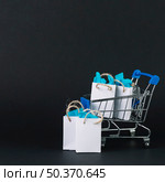 toy shopping trolley with gifts packets. Стоковое фото, агентство Ingram Publishing / Фотобанк Лори
