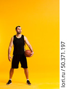 front view basketball player posing with ball close hip copy space. Стоковое фото, агентство Ingram Publishing / Фотобанк Лори