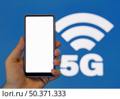 hand holding phone with 5g symbol background. Стоковое фото, агентство Ingram Publishing / Фотобанк Лори
