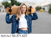 medium shot woman holding skateboard. Стоковое фото, агентство Ingram Publishing / Фотобанк Лори