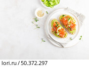 Open sandwiches with salted salmon, guacamole avocado and microgreens. Seafood. Healthy food. Top view. Стоковое фото, агентство Ingram Publishing / Фотобанк Лори