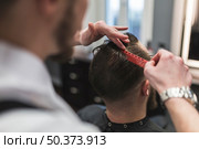 faceless barber combing hair man before cutting. Стоковое фото, агентство Ingram Publishing / Фотобанк Лори