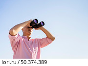low angle man watching through binocular. Стоковое фото, агентство Ingram Publishing / Фотобанк Лори
