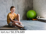 portrait smiling boy sitting exercise mat looking camera. Стоковое фото, агентство Ingram Publishing / Фотобанк Лори