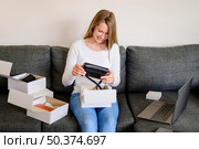 portrait woman unboxing products ordered online. Стоковое фото, агентство Ingram Publishing / Фотобанк Лори