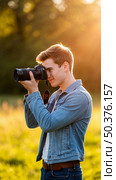 A man is taking a picture of a beautiful sunset. Стоковое AI-изображение, AI-художник Ярославский Максим / Фотобанк Лори