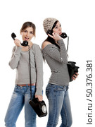 Two young women talking with old telephones - Isolated on white. Стоковое фото, агентство Ingram Publishing / Фотобанк Лори