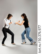Two young beautiful sisters having fun simulating a fight  - This models are true twins. Стоковое фото, агентство Ingram Publishing / Фотобанк Лори