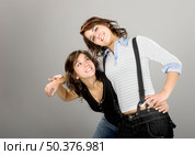 Two young beautiful sisters having fun - This models are true twins. Стоковое фото, агентство Ingram Publishing / Фотобанк Лори