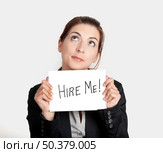 Business woman holding a card board with the text message "Hire me" Стоковое фото, агентство Ingram Publishing / Фотобанк Лори